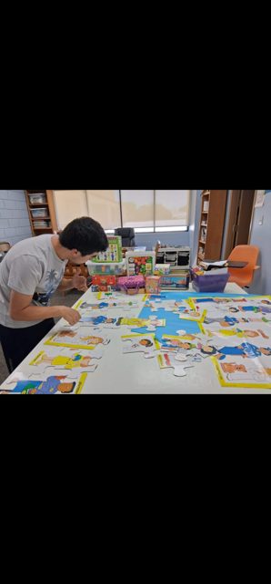 People creating colorful artwork around a table