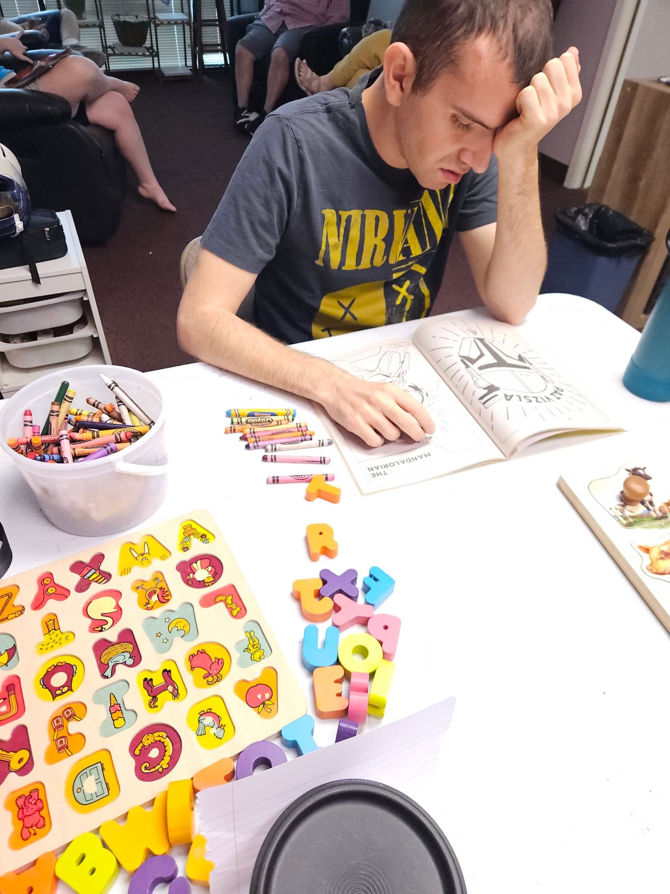 A person coloring at a table with crayons