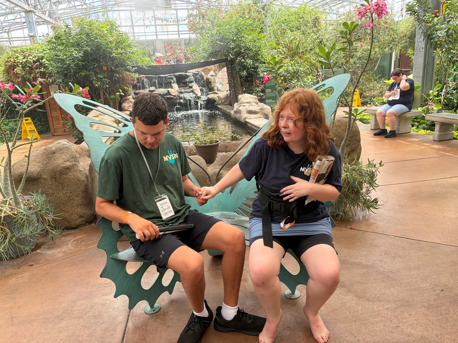 Two people seated during a butterfly-garden outing